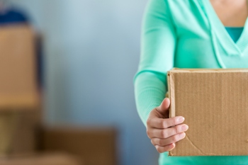 Cropped shot of a woman's torso holding a large box