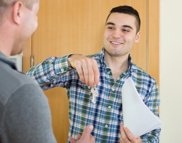 A man handing over a set of keys to another man